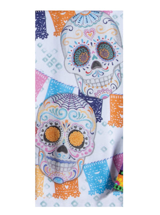 A white fabric item, likely a towel or scarf, featuring a colorful Day of the Dead sugar skull pattern with festive papel picado banners in orange, blue, pink, and purple.