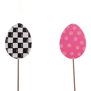 Two decorative eggs on sticks with checkered and polka dot patterns on a white background.