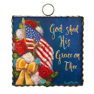 Decorative plaque with American flag, cross, flowers, and 'God shed His Grace on Thee' text.