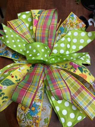 Colorful decorative bow with polka dots and floral patterns on a wooden surface