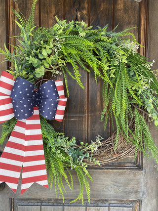 Wreath with American flag decorations on a wooden door