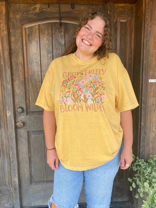Yellow T-shirt with flowers and "Grow Freely Bloom Wildly"