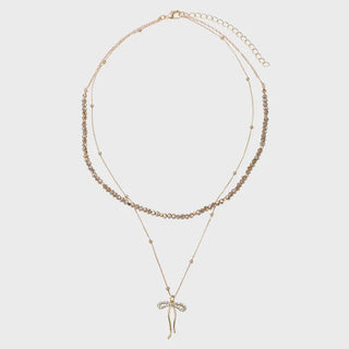 Two gold necklaces with a bow pendant