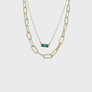 Gold chain necklace with a green gemstone 