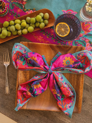 Colorful floral napkin tied on a wooden plate