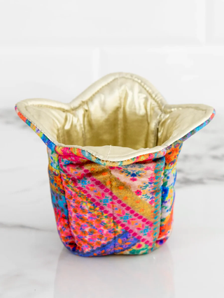Colorful fabric basket with a gold interior on a white background