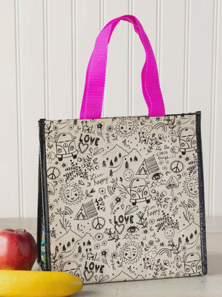 Tote bag with black doodle patterns and pink handle on a white surface