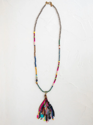 Colorful beaded necklace with tassel on a white background