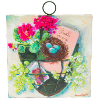 Decorative tile with a bird's nest, flowers, and a book titled 'Jardin Journal'.