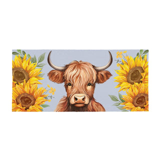 Painting of a highland cow between two sunflowers on a light blue background
