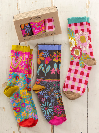 Colorful patterned socks with a box labeled 'Natural Life' on a wooden surface.