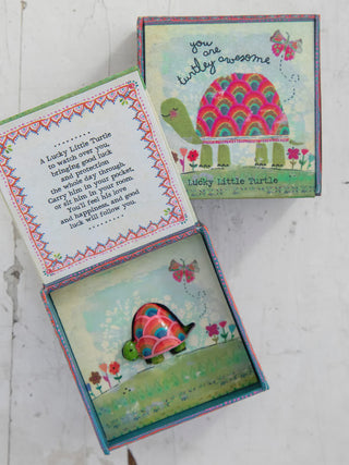 Decorative turtle-themed box with colorful design and text on a white surface