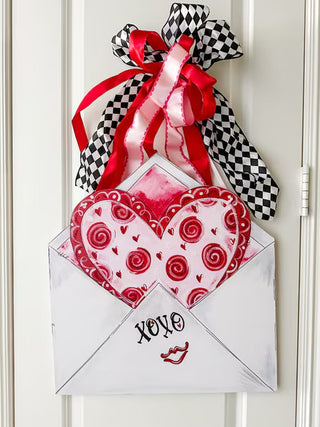 Decorative heart with red swirls and 'XO' text in an envelope pvc door hanger