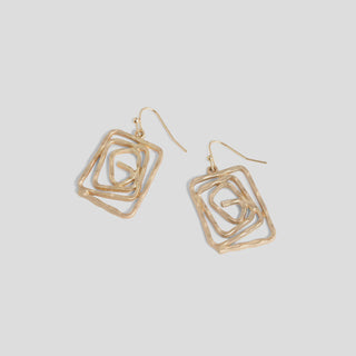 Gold geometric earrings on a light gray background