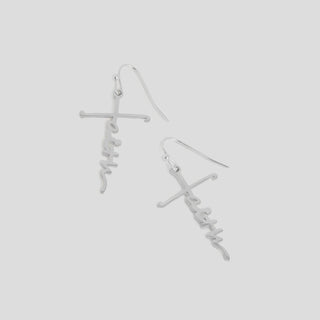Silver earrings with 'faith' inscription on a light gray background