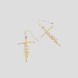 Gold cross-shaped earrings on a light gray background