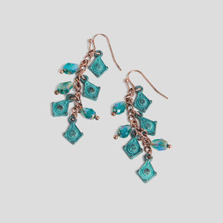 Turquoise and rose gold earrings on a light gray background
