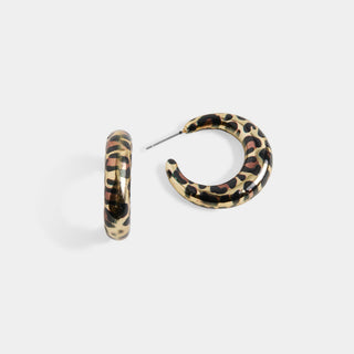 A pair of hoop earrings with a leopard print pattern in black, brown, and beige, shown on a light gray background.