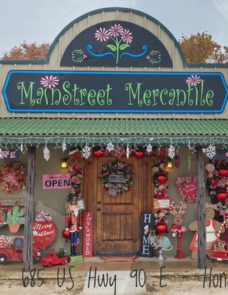Storefront with 'MainStreet Mercantile' sign and festive decorations on a cloudy day.