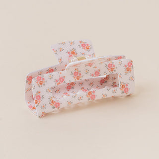 Floral-patterned hair clip on a beige background