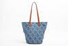 Blue patterned tote bag with brown handles on a white background